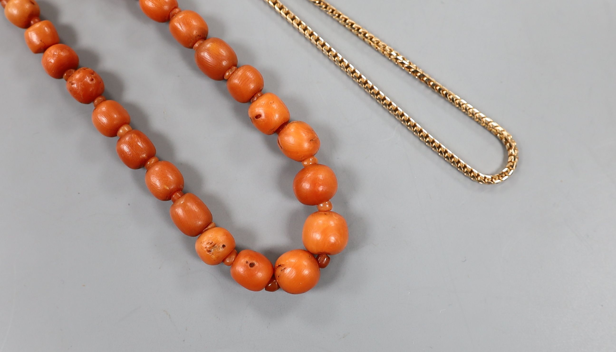 A group of graduated Egyptian coral beads, now strung on a later yellow metal necklace, 62cm